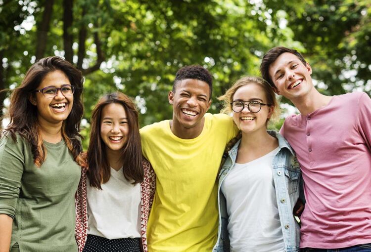 Diverse group of five happy youth posing for the camera