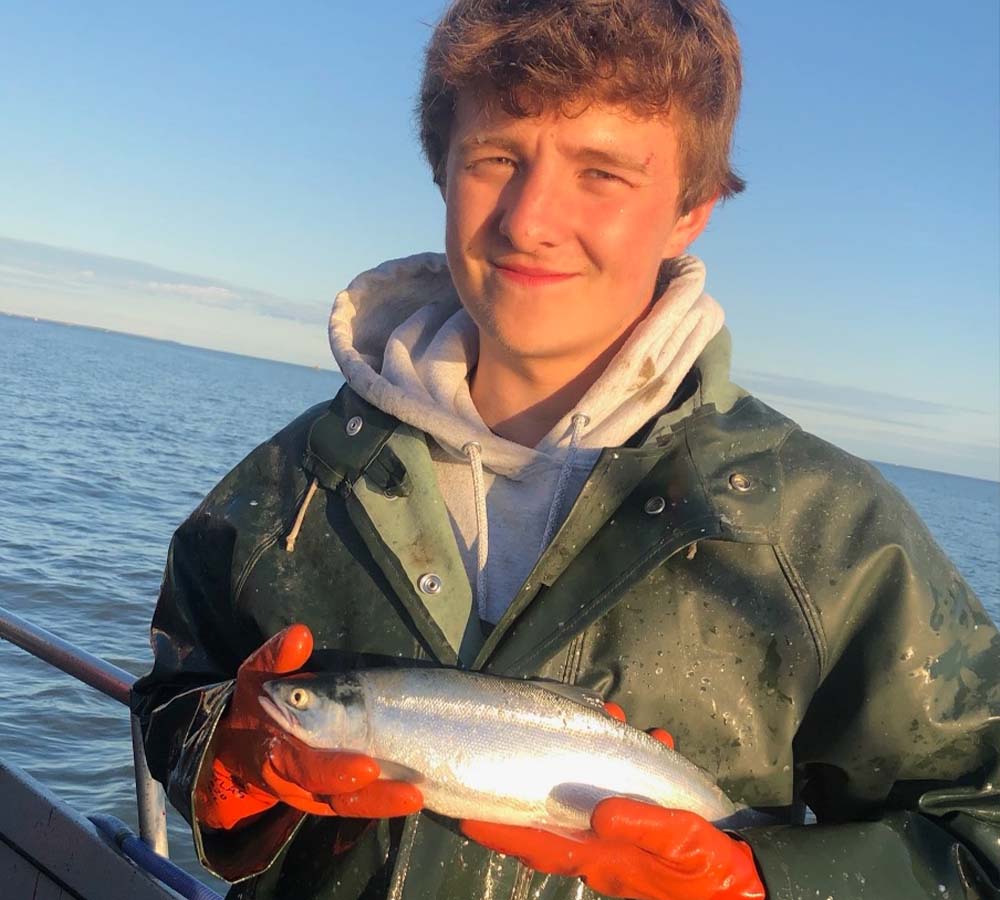 Teen on boat holding fish