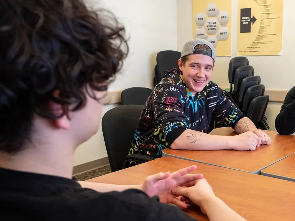 Youth smiling in conversation in group counseling