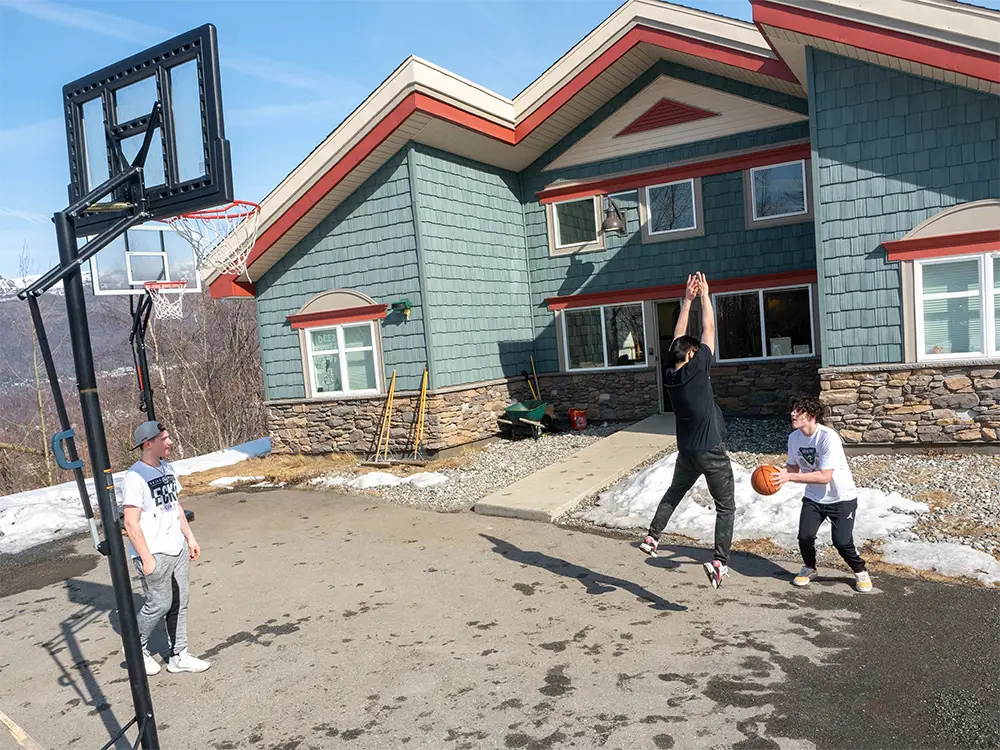 Teenagers playing basketball outside a youth residential treatment center