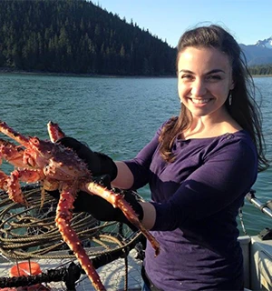 Photo of KC holding up a large crab near the water